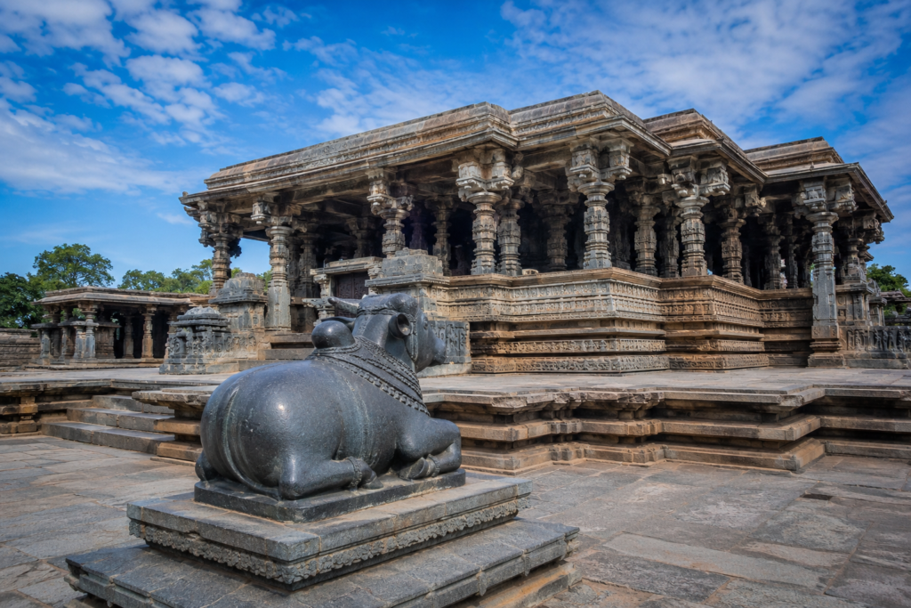 Ancient Thousand Pillar Temple in Hanamkonda, Telangana, featuring intricate Kakatiya stone carvings, beautifully sculpted pillars, and the iconic black basalt Nandi statue under a blue sky.