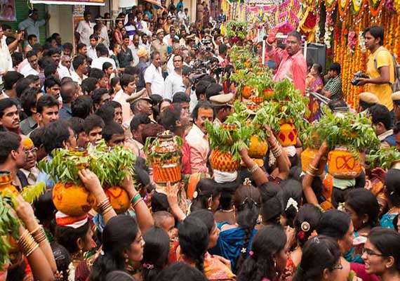 Bonalu Festival celebration in Telangana with women carrying Bonam offerings to Goddess Mahakali during a traditional temple procession.